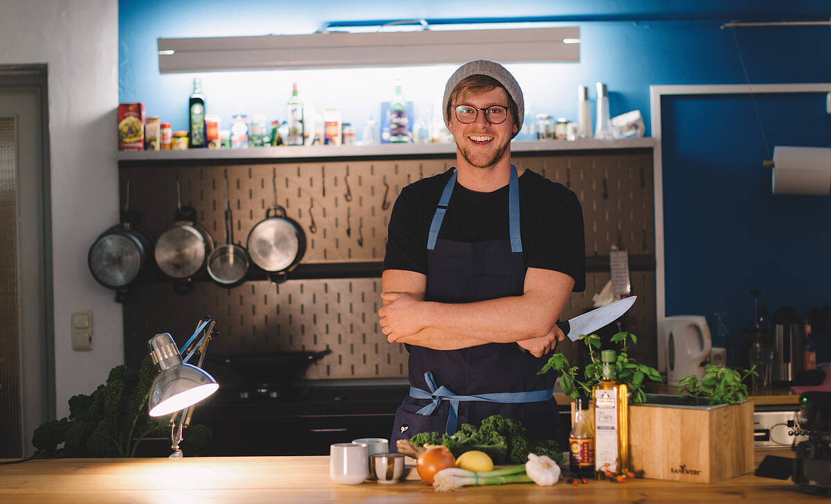 Koch in der Küche mit Grünkohl