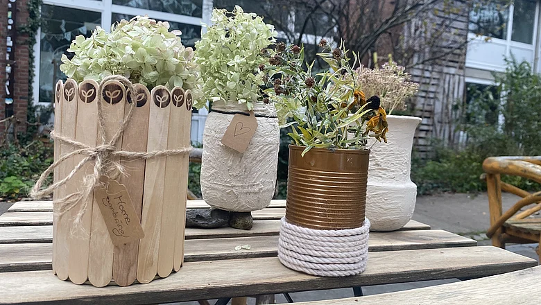 Ein selbstgebauter Blumentopf, bedeckt mit Pflanzstäben mit Rankwerk-Branding